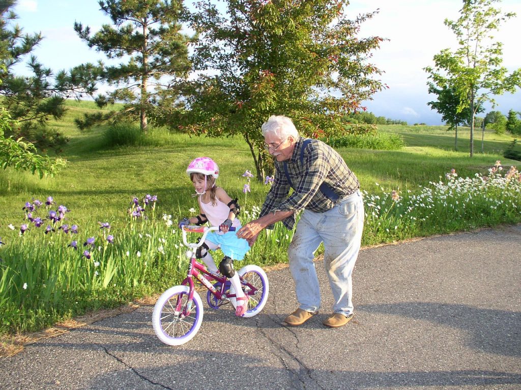 dziadek uczy wnuka jazdy na rowerze